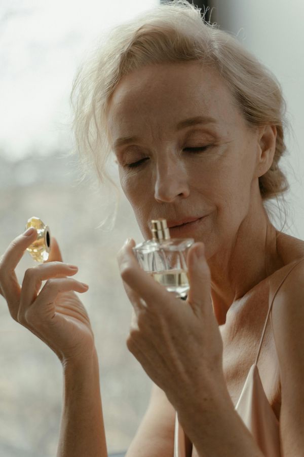 O femeie în vârstă mirosind parfum | Sursă: Pexels